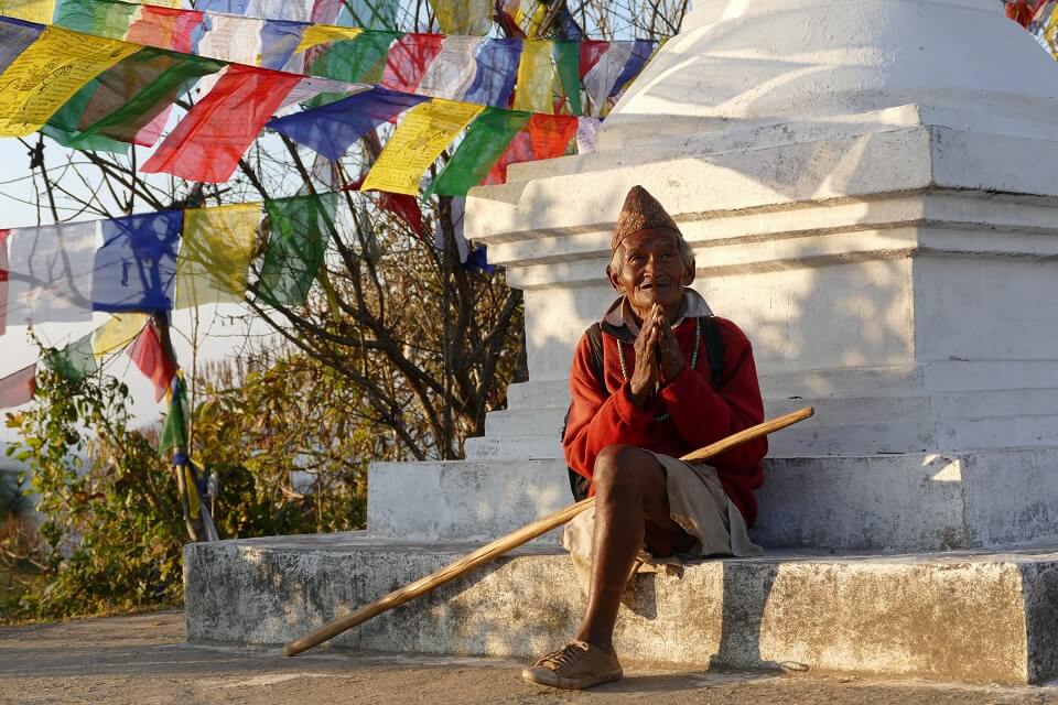 Kathmandu vallei trekking – begroeting door een oude man aan het klooster van Namobuddha